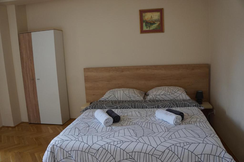 een slaapkamer met een bed met 2 kussens erop bij Apartments Bella in Užice