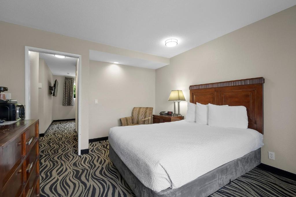 Cette chambre comprend un grand lit et une télévision. dans l'établissement Astoria Rivershore Motel, à Astoria