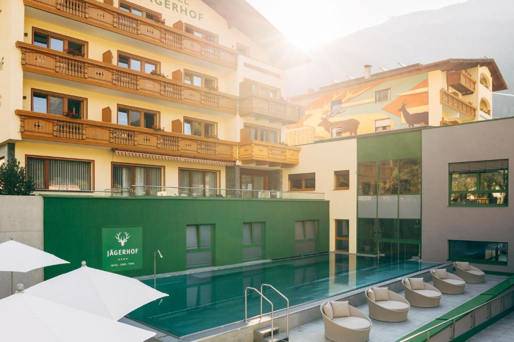 un hotel con piscina di fronte a un edificio di Haus Oberdorf a Zams