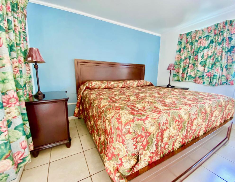 a bedroom with a bed and two curtains at Glades Motel - Naples in Naples