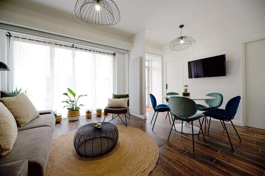 een woonkamer met een bank en een tafel en stoelen bij Luxury home near Tour Eiffel in Parijs
