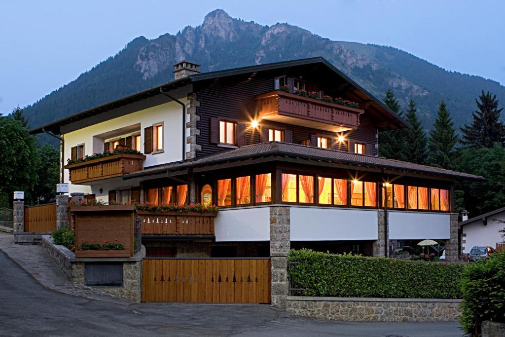 a large house with a mountain in the background at Max Meublè in Castione della Presolana