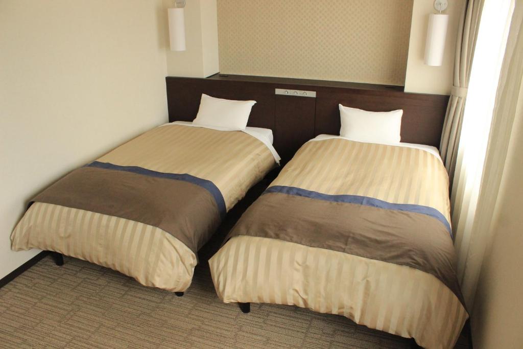 Postel nebo postele na pokoji v ubytování Kochi Hotel