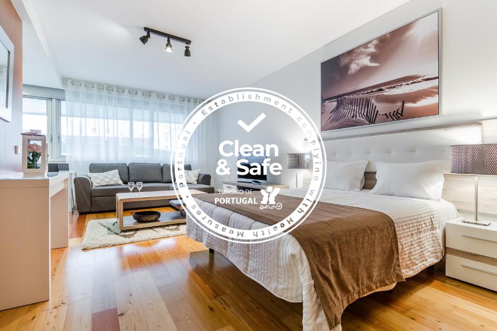 una camera da letto con un letto con un cartello pulito e sicuro di RS Porto Boavista Studios a Porto