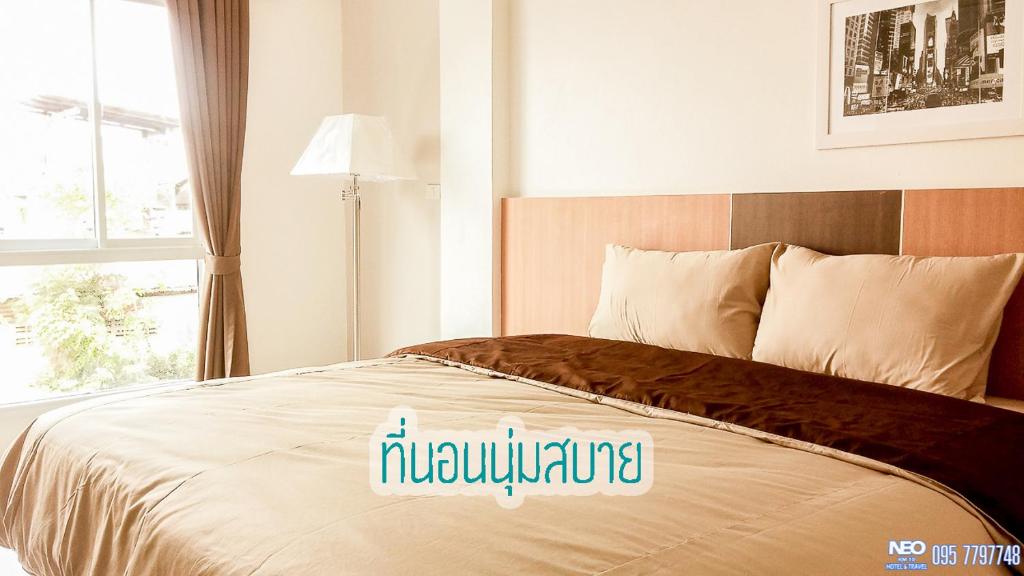 - une chambre avec un grand lit et une fenêtre dans l'établissement Neo km10โรงแรมที่พักใกล้สนามบินอู่ตะเภา แสมสาร สัตหีบ บ้านฉาง, à Sattahip