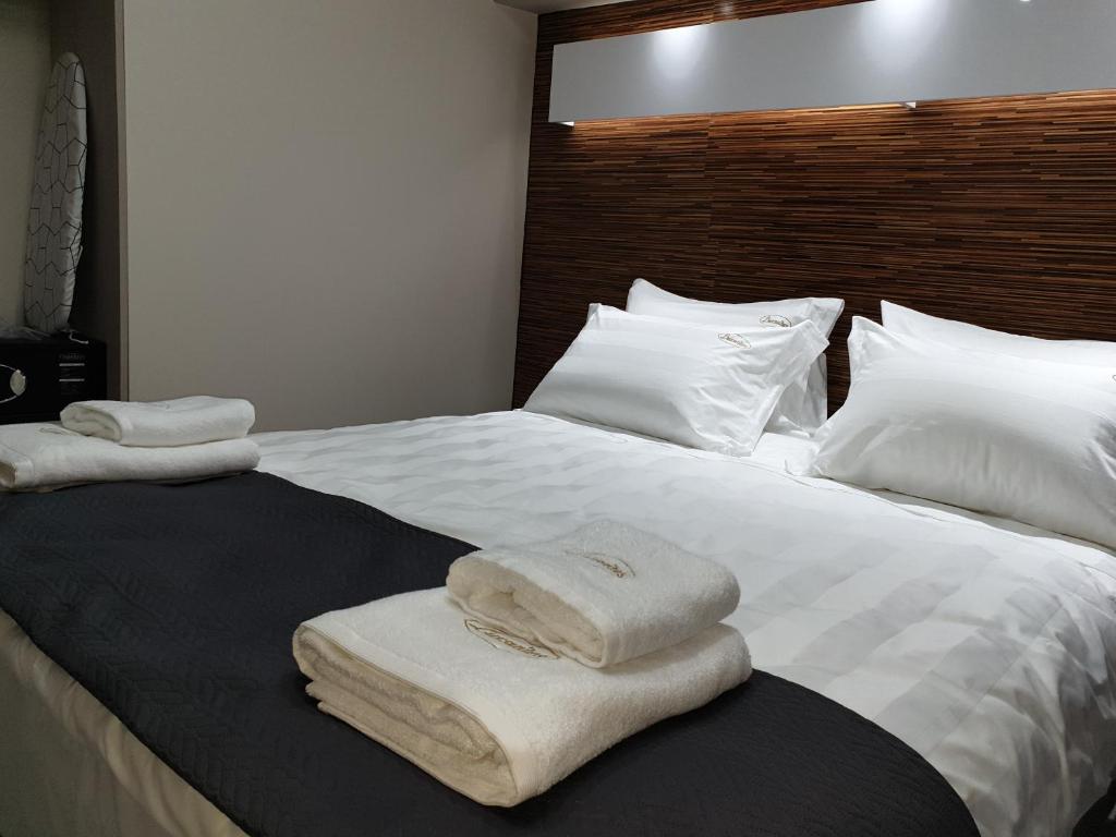 Una cama con dos toallas encima. en luxrooms en Ofrínion