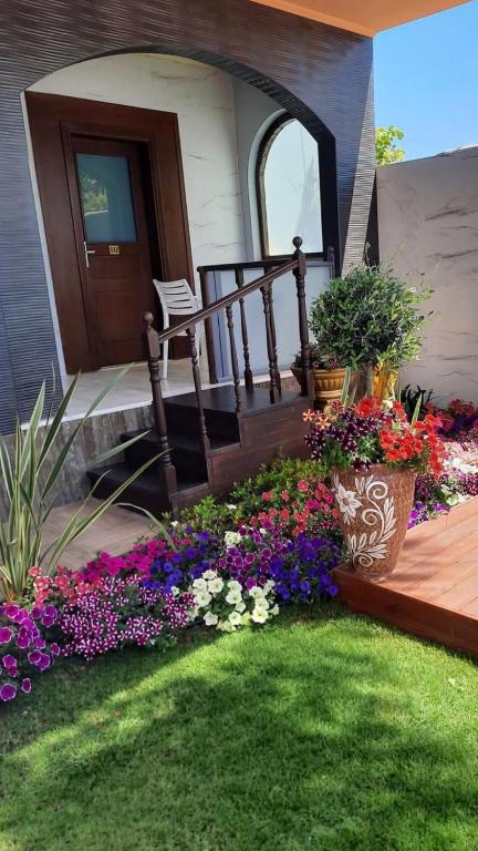a porch with a bunch of flowers in a yard at Paradice Hotel Luxury Suites-Near zorbas Beach-FREE Breakfast in Stavros