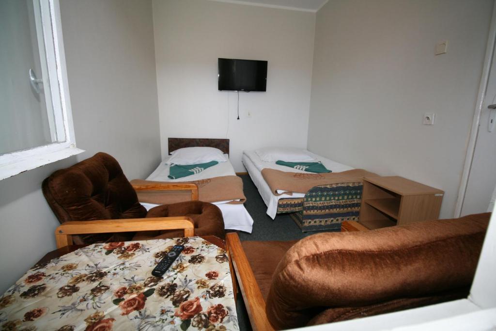 a room with a room with a bed and chairs at OW Gromada Pod Topolami in Międzyzdroje