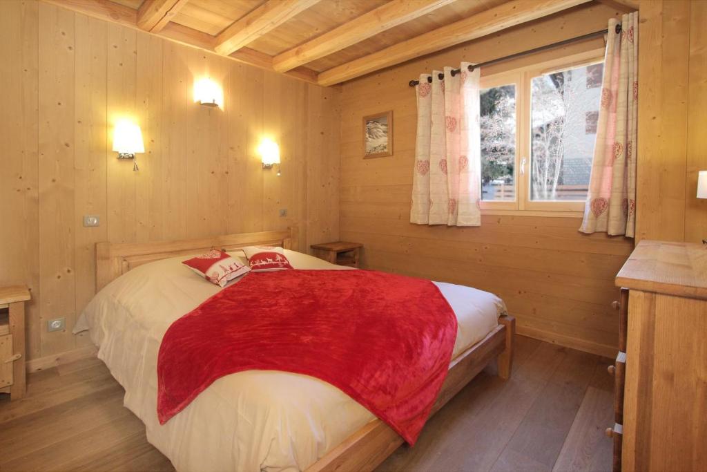 um quarto com uma cama com um cobertor vermelho em Chalet Faverot 1 em Les Deux Alpes