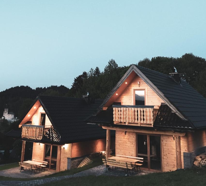 a house with a black roof and a balcony at DOMKI STROME ZACISZE in Niedzica Zamek