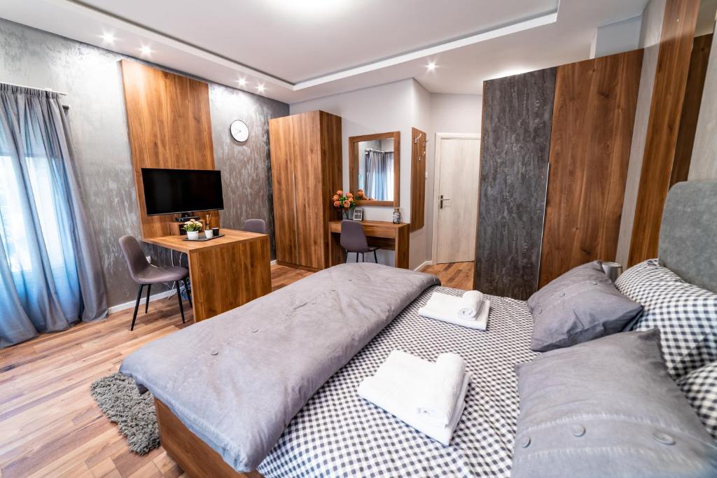 1 Schlafzimmer mit 2 Betten, einem Schreibtisch und einem TV in der Unterkunft Ivi Place Apartments in Novi Sad