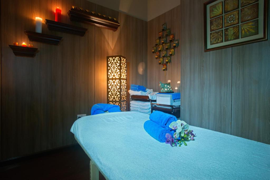 a room with a bed with blue chairs and a desk at Ayla Hotel in Al Ain