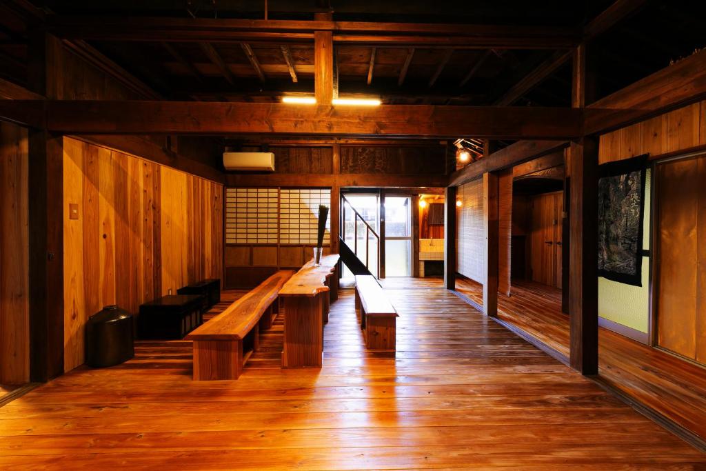 una fila di panche in una stanza con pavimenti in legno di 屋久杉楼 七福 a Yakushima