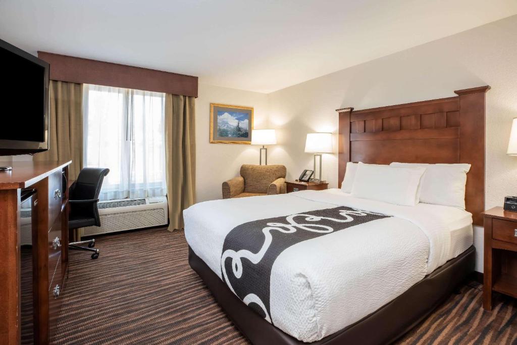 a hotel room with a bed and a desk and a television at La Quinta Inn by Wyndham Bend in Bend