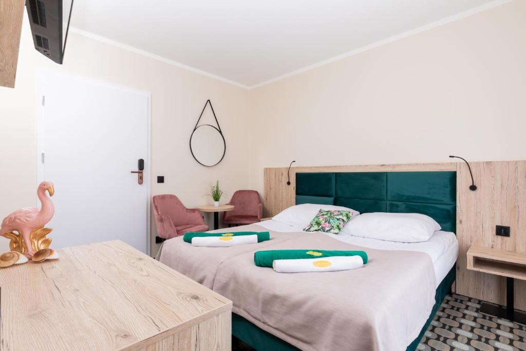 a bedroom with two beds with towels on them at Flamingo in Pobierowo