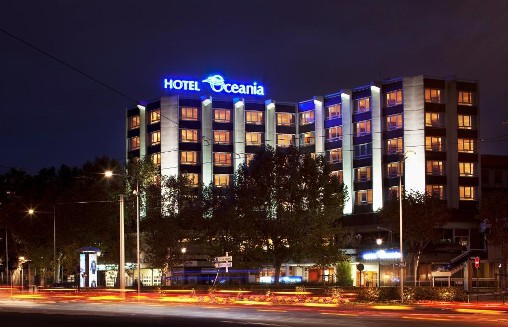 a hotel with a sign on top of it at night at Oceania Clermont Ferrand in Clermont-Ferrand