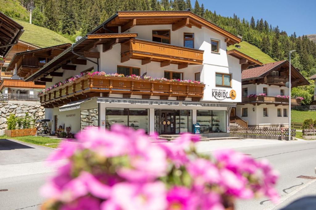 Um edifício com flores cor-de-rosa à frente. em Haus Kreidl em Tux