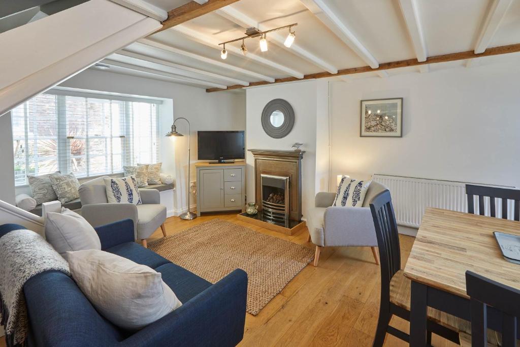 uma sala de estar com um sofá azul e uma lareira em Host & Stay - Amber Cottage em Whitby