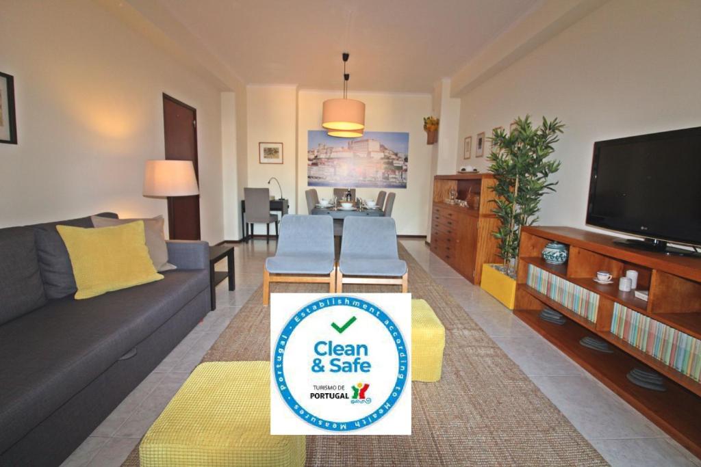a living room with a sign that reads clean and safe at Bombarda House & Home in Porto