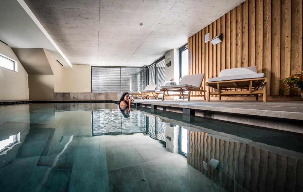 a woman is swimming in a swimming pool at Agritur Renetta in Tassullo