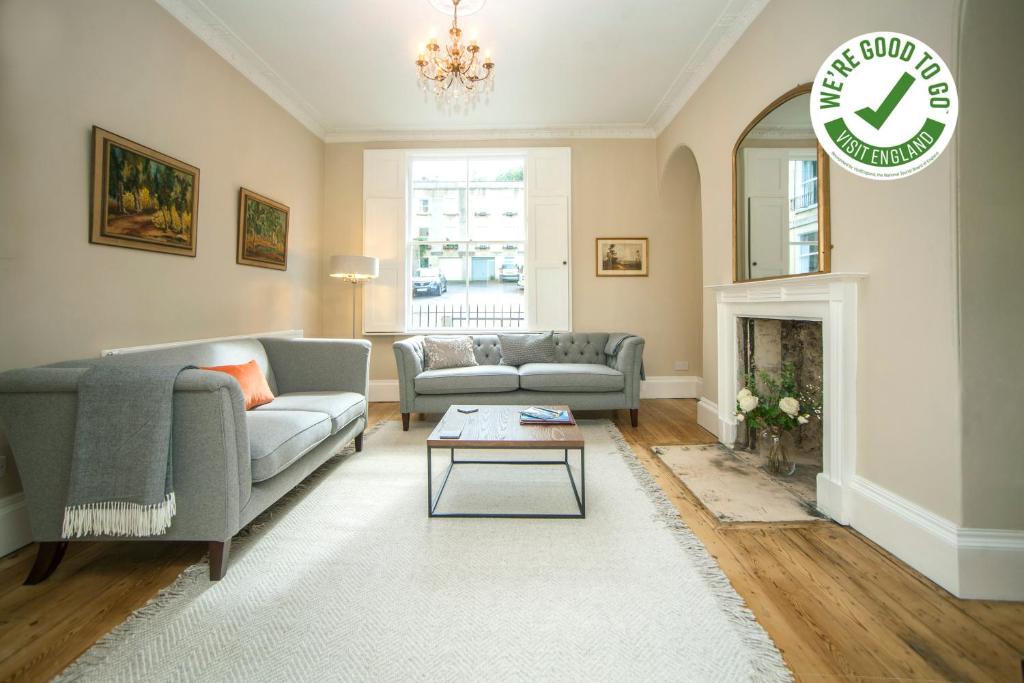 a living room with two couches and a fireplace at Garden Apartment - 11 Southcot Place in Bath