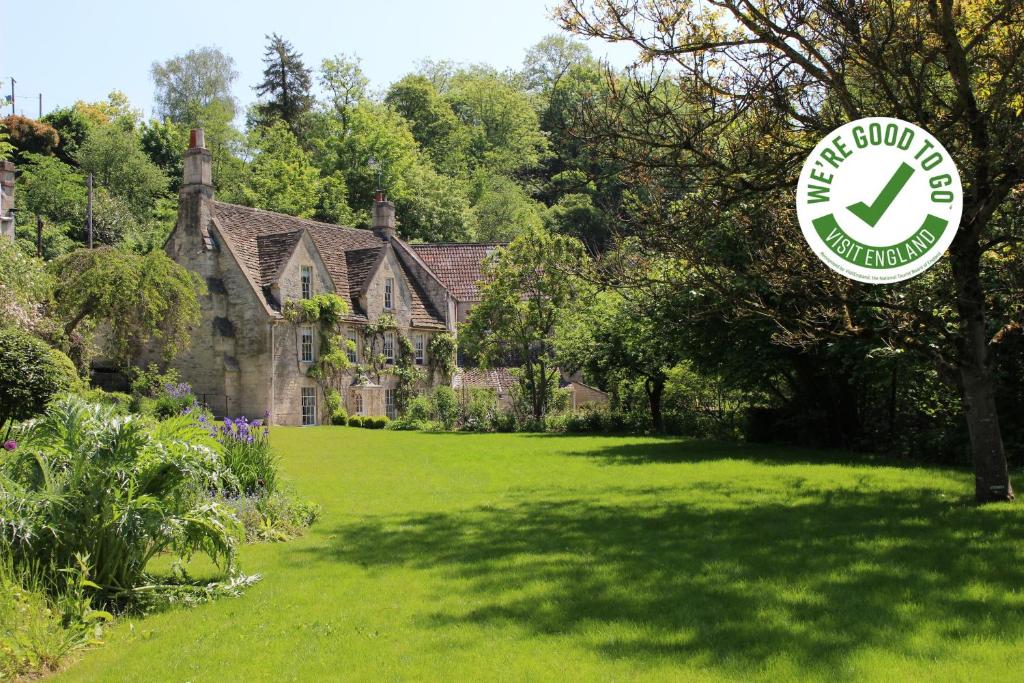 une maison avec un panneau devant une cour dans l'établissement Midford Mill, à Bath