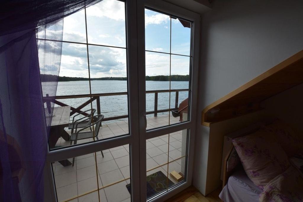 a room with a window looking out at the water at Noclegi pod Gąską in Olecko