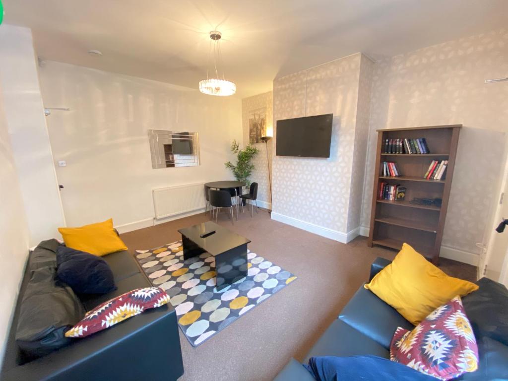 a living room with a blue couch and yellow pillows at Warwick Street Professional Lets in Newcastle upon Tyne