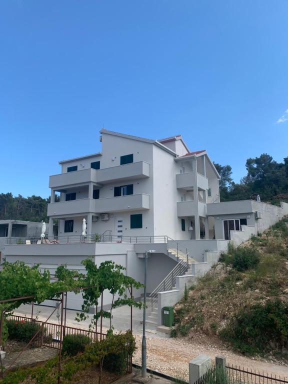 a white building with stairs on a hill at Villa Milena in Trogir