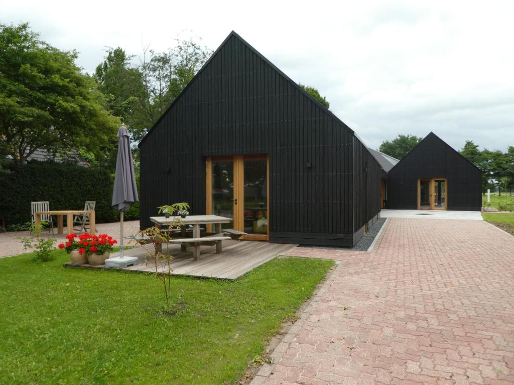 a black house with a patio and an umbrella at BenB Bunne in Bunne