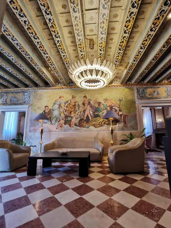 a living room with a ceiling with a painting on the wall at Hotel Gardena in Venice
