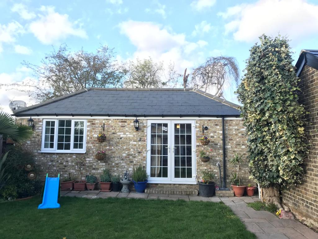 a detached house with a pitched roof at cosy cottage annex in Fairlop in Ilford