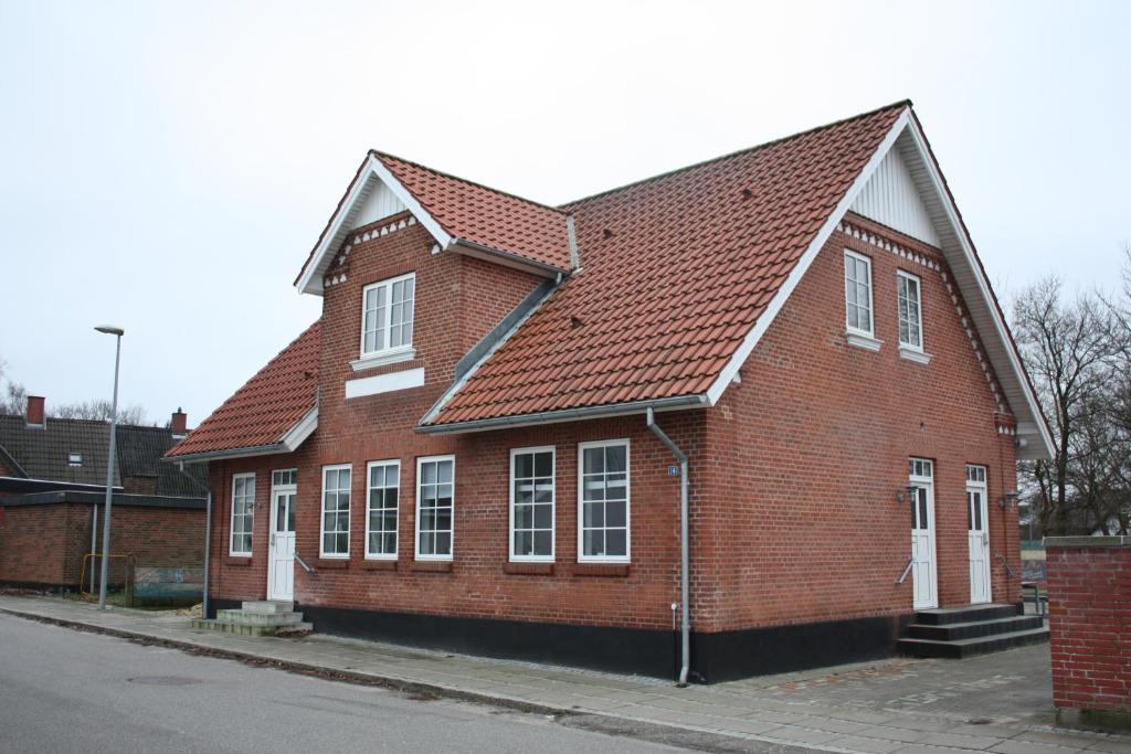 un bâtiment en briques rouges avec un toit brun dans l'établissement Skibbild Bed no Breakfast, à Herning