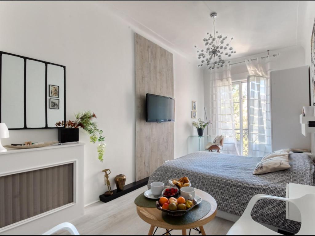 - une chambre avec un lit et une table avec un bol de fruits dans l'établissement La Croisette - Superbe studio au mythique Palais Miramar, à Cannes