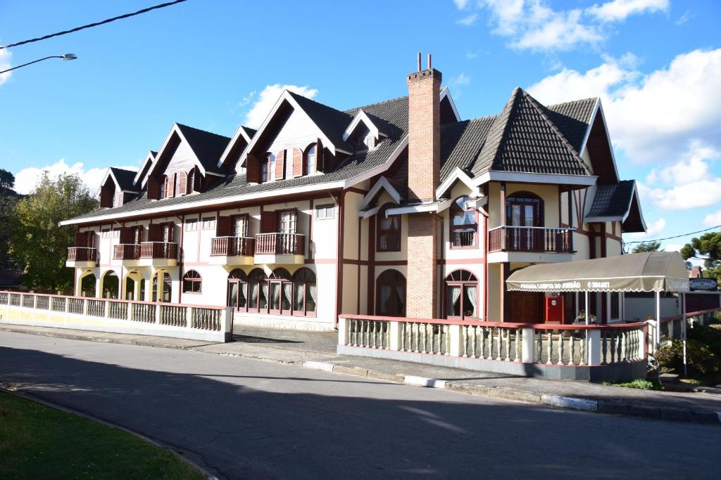 une grande maison sur le côté d'une rue dans l'établissement Pousada Campos do Jordão, à Campos do Jordão