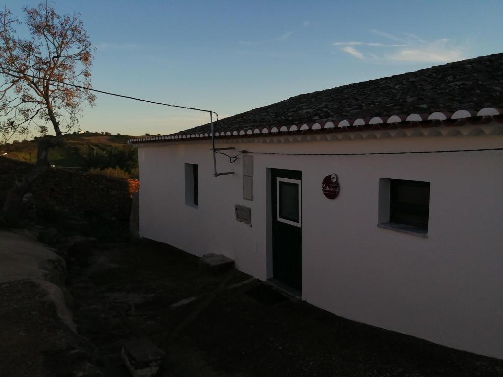 ein weißes Gebäude mit einer Tür im Hof in der Unterkunft CASA AVÓ CATARINA Mesquita, turismo na aldeia in Espírito Santo