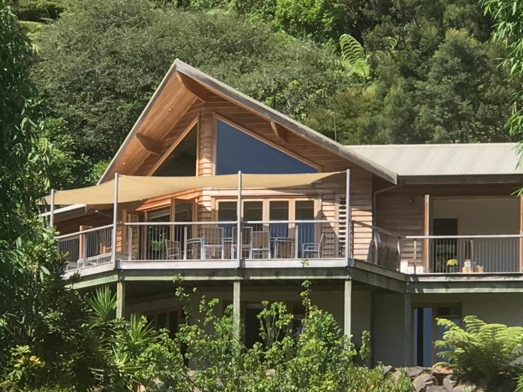 une grande maison entourée d'une terrasse. dans l'établissement Waiotahi Valley Lodge, à Thames