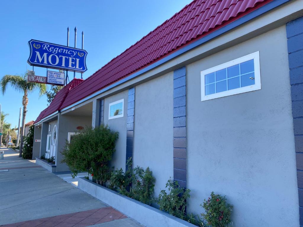 a building with a motel sign and a sidewalk at Regency Motel in Brea