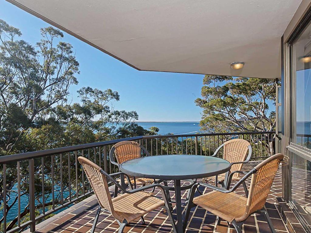 stół i krzesła na balkonie z widokiem na ocean w obiekcie Skyline, 6,12 Thurlow Avenue - Unit with stunning views, Aircon and Wi-fi w mieście Nelson Bay