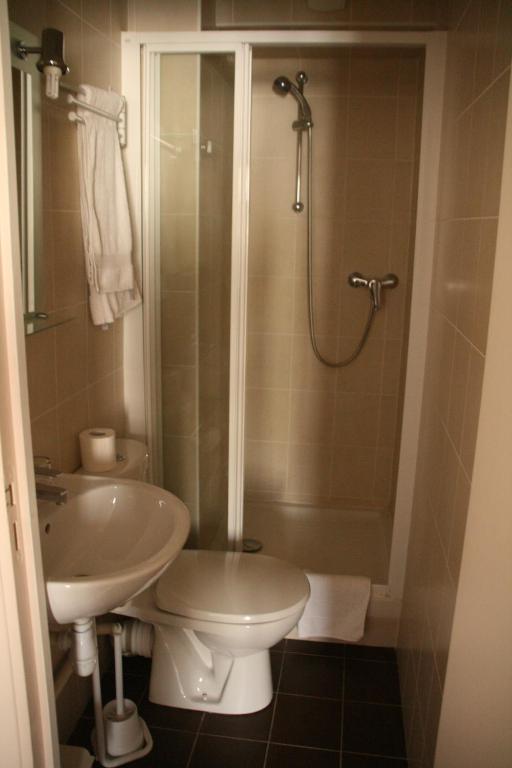 a bathroom with a sink and a shower and a toilet at Hôtel du Roussillon in Paris