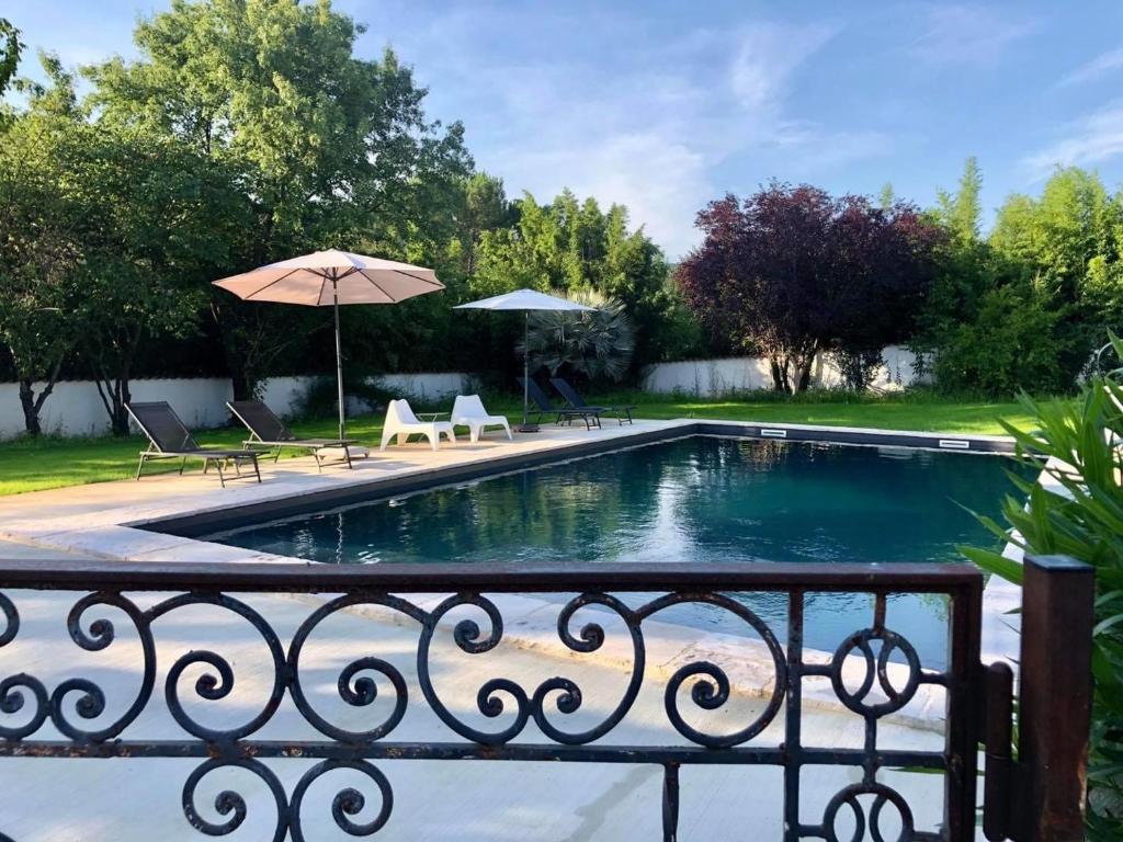 einen Pool mit Stühlen und einem Sonnenschirm in der Unterkunft Domaine de Mont Redon in Le Puech