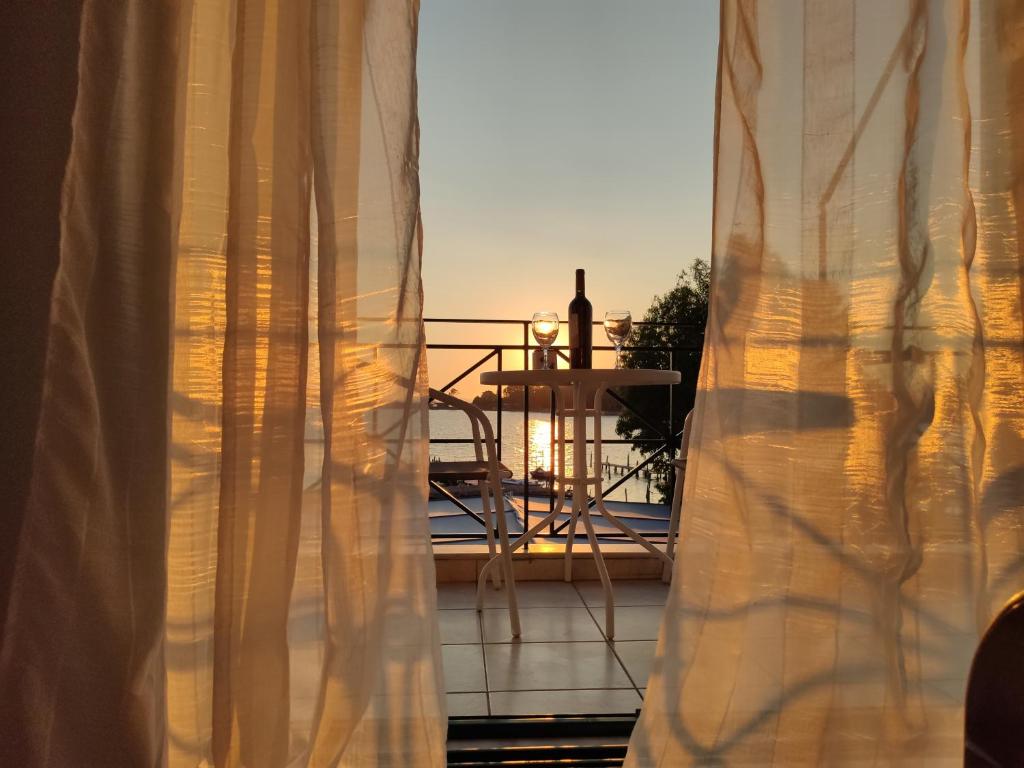 een raam met uitzicht op een balkon met een tafel bij Island Apartments in Mesolongion