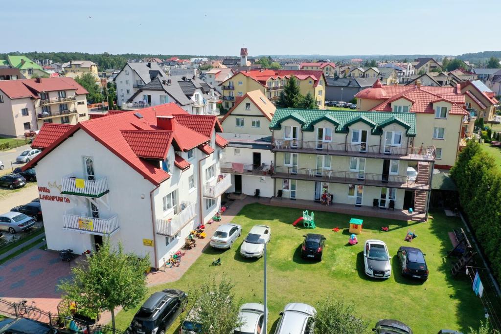 a group of buildings with cars parked in a yard at Larapunta in Karwia