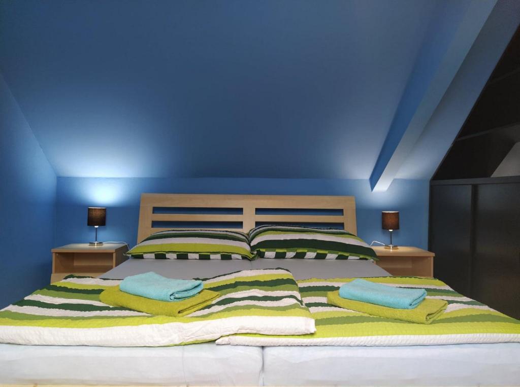 1 dormitorio azul con 1 cama grande y 2 almohadas en Ubytování Prušánky, en Prušánky