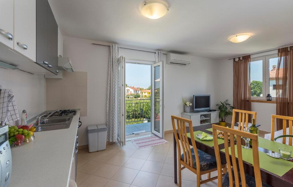 a kitchen and dining room with a table and a window at Apartment Nensi in Poreč
