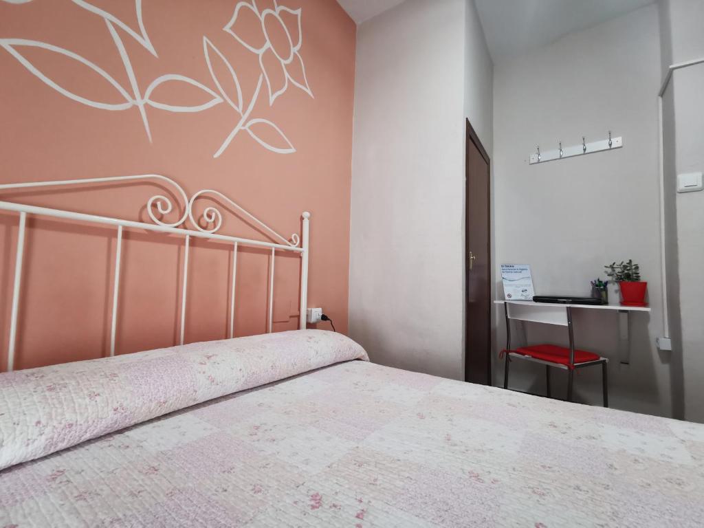 Un dormitorio con una cama y una silla roja. en Hostal Senero, en Mérida