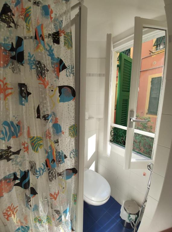a bathroom with a toilet and a shower curtain at Chez Tamara with private parking and air conditioned in Monterosso al Mare