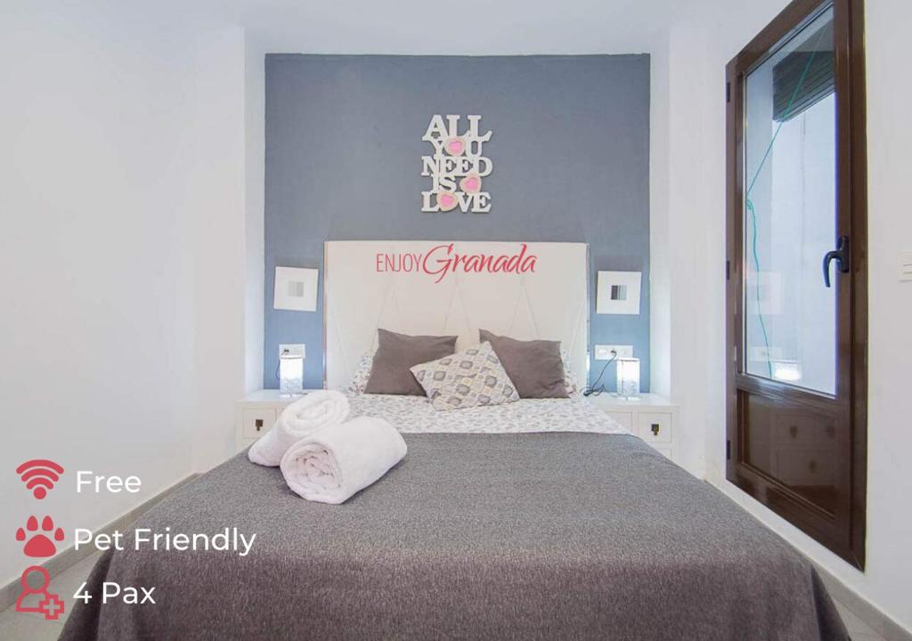 1 dormitorio con 1 cama con 2 toallas en EnjoyGranada REALEJO DELUXE 1A, en Granada