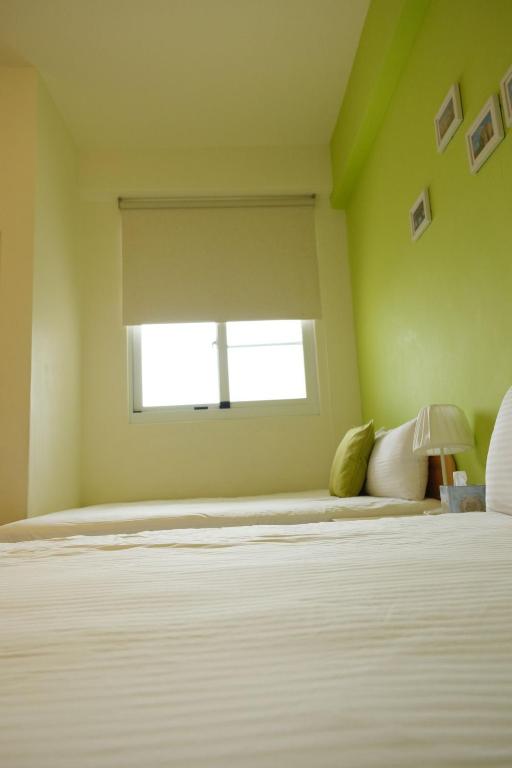 a bedroom with a large bed with a window at Bonjour, Paris in Taitung City