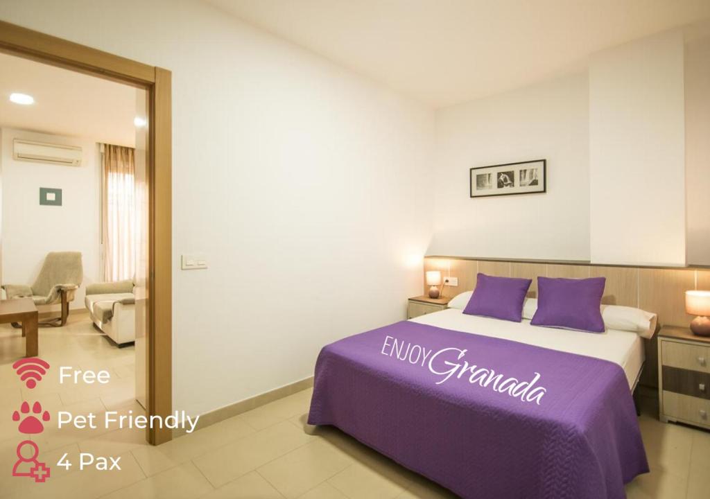 1 dormitorio con 1 cama con almohadas moradas en EnjoyGranada GRAN VIA B-A & Parking opcional, en Granada